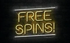 Neonskilt med teksten Free Spins på en mørk murvegg