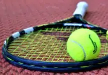 Tennisracket og tennisball på en tennisbane