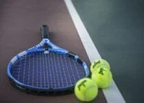 Tennisracket og tennisball på en tennisbane